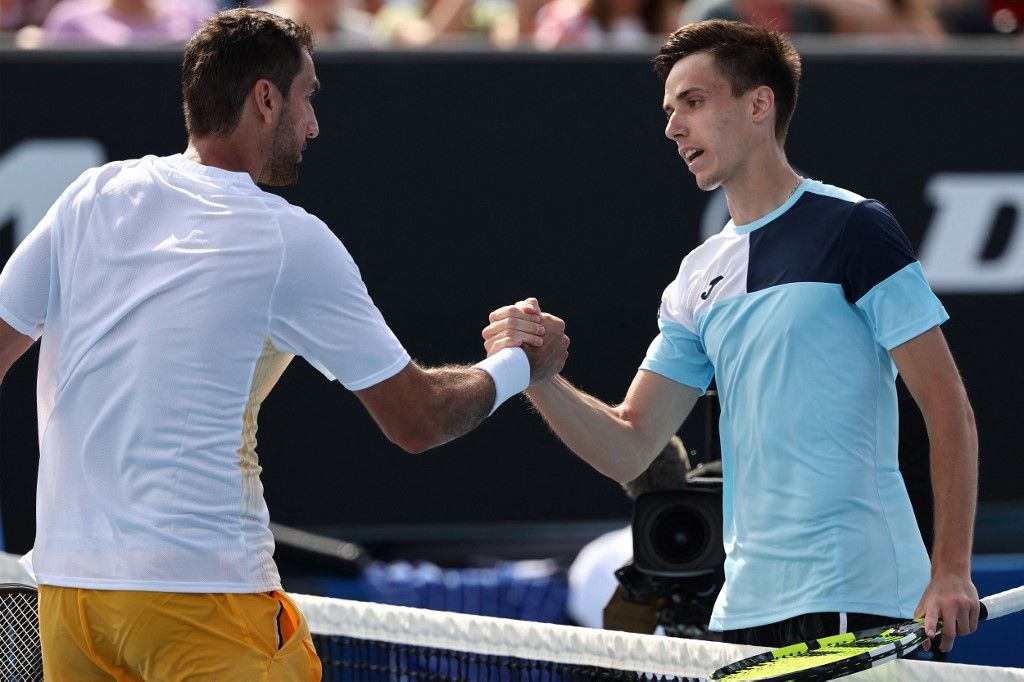 Hungary's Fabian Marozsan (R) shakes hands with Croatia's Marin Cilic after their men's singles match on day one of the Australian Open tennis tournament in Melbourne on January 14, 2024. (Photo by David GRAY / AFP) / -- IMAGE RESTRICTED TO EDITORIAL USE - STRICTLY NO COMMERCIAL USE --